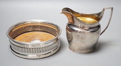 A George III silver mounted wine coaster, Sheffield, 1805, diameter 13.2cm and a George III silver cream jug, with later engraved inscription, London, 1801(a.f.).